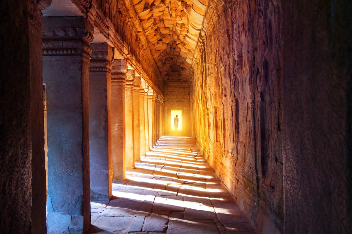 Repeating doorways and sandstone walls beside Sunlit Passage at Angkor Wat in Siem Reap, Cambodia.