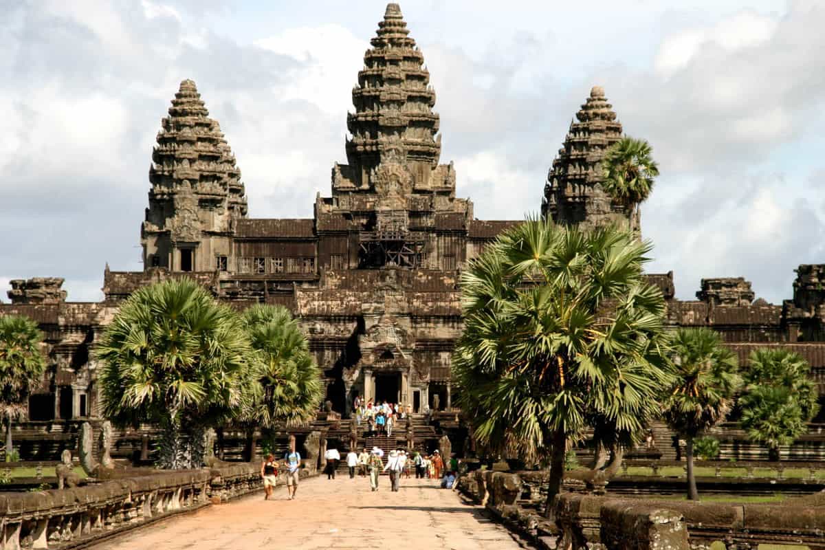 Angkor Wat Western Causeway amid palm trees and stone balustrade in Siem Reap, Cambodia.